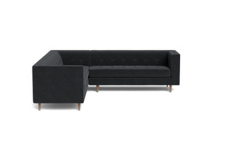 The Gramercy sofa sectional, in dark brown leather, is a modern couch with a vintage feel
